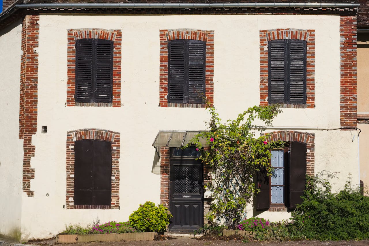 Rustic facade of a French house with wooden shutters in Grandchamp, IDF.