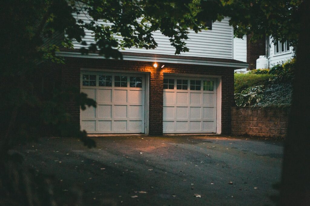 Warm evening view of a suburban garage with soft lighting creating a cozy atmosphere.